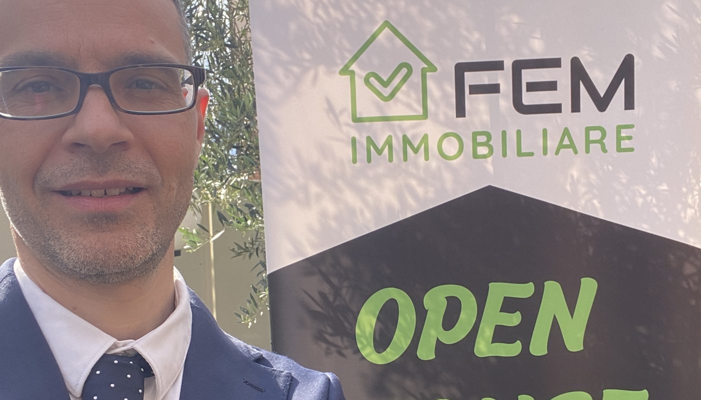 Michele Brizi accanto al banner Open House di FEM Immobiliare
